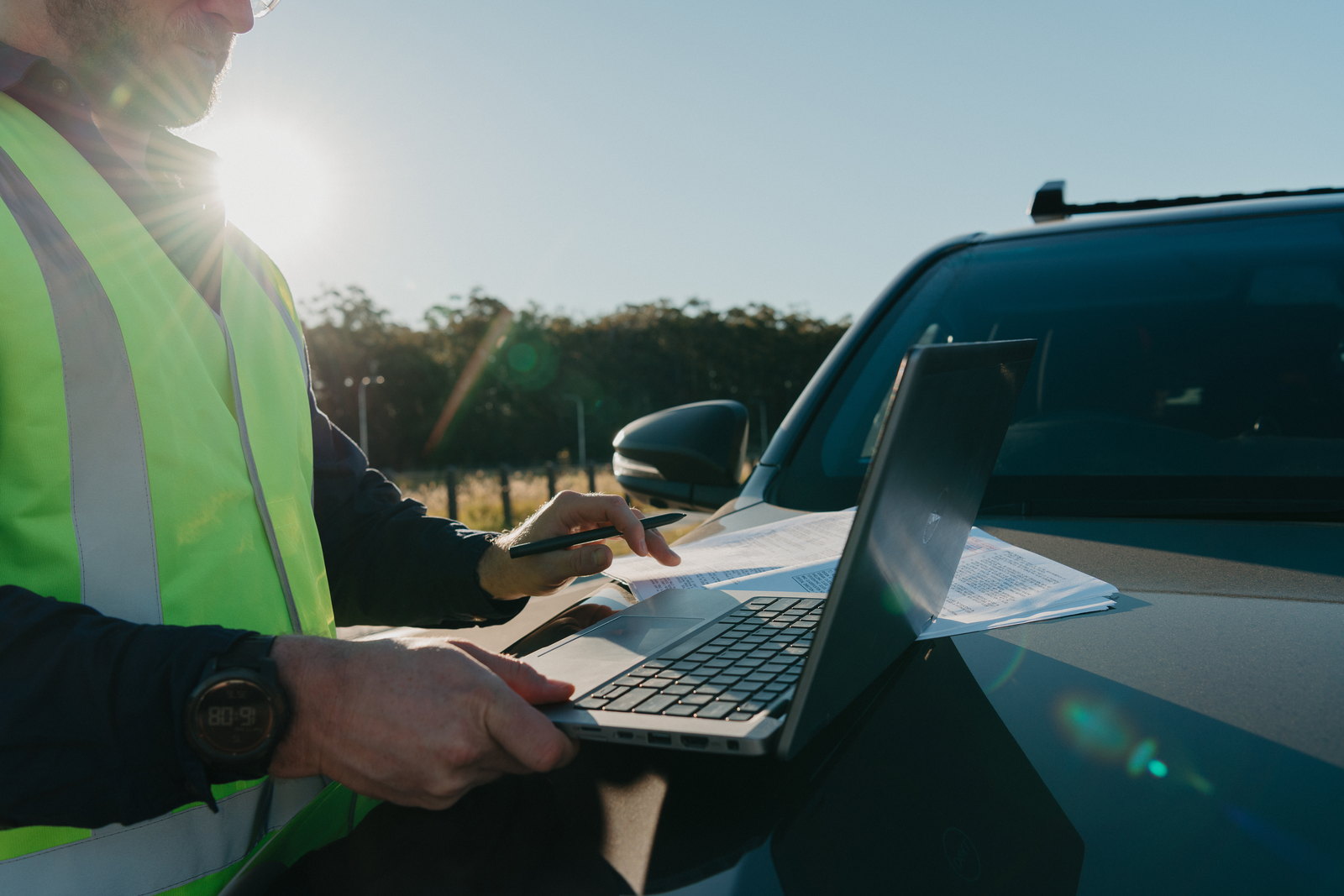 Reviewing drawings and site documentation on a laptop at a project site